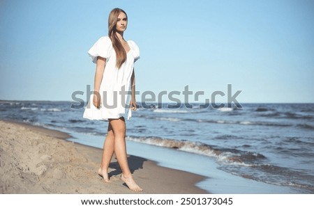 Similar – Young, long-legged woman sitting on the Baltic Sea beach