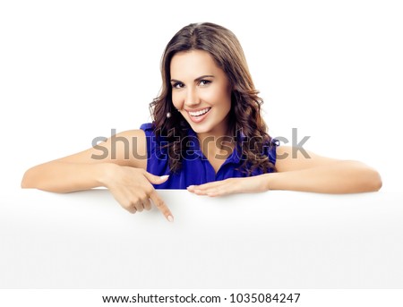 Happy smiling beautiful young woman in blue smart casual clothing showing blank signboard or copyspace for slogan or text, isolated against white background