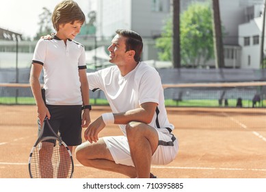 Happy Smiling Boy Glancing At Tennis Coach