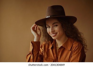 Happy Smiling Brunette Woman Wearing Trendy Brown Hat, Shirt Dress, Posing In Studio. Copy, Empty Space For Text