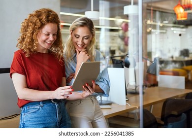 Happy smiling business women working together online on a tablet in office - Shutterstock ID 2256041385