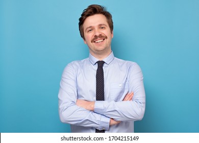 Happy smiling businessman smiling being confident on blue wall. Studio shot