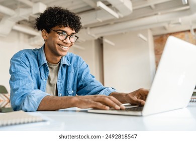 Happy smiling businessman freelancer student it worker manager using laptop computer for working remote distant studding doing project homework tasks at office desk sitting in cafe workplace