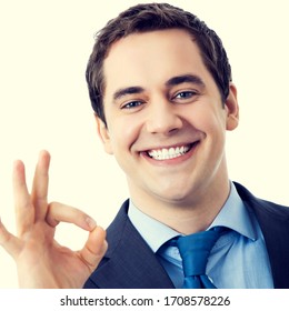 Happy smiling businessman with okay gesture. Success in business concept. Man in confident suit and blue tie at studio picture, isolated over yellow. Square composition. - Shutterstock ID 1708578226