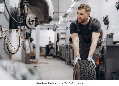 Happy Smiling Car mechanic working in garage and changing wheel alloy tire. Repair or maintenance auto service. - Powered by Shutterstock