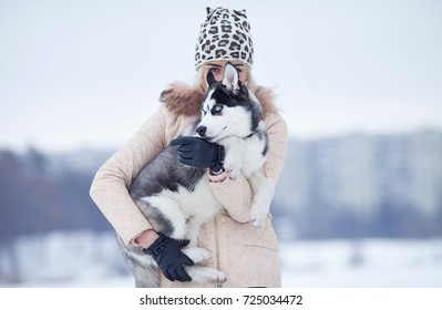 Happy Smiling Caucasian blonde Woman and Her Husky Dog. Playing Outdoors in Winter White Forest Together.
