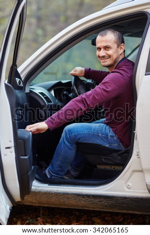 Happy smiling caucasian man with his new car