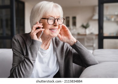 Happy smiling caucasian old senior elderly woman lady grandmother talking communicating with friends, grandchildren, colleagues on cellphone, smart phone online at home - Shutterstock ID 2115834884