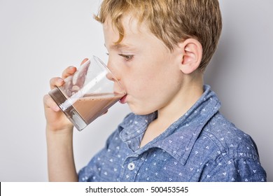 A Happy Smiling Child Drinking Chocolate Milk Isolated On White