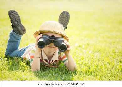 Happy Smiling Child With Hat Play With Binoculars In A Garden