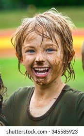 Happy, Smiling Child With Muddy Face After Sport