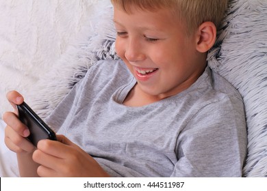 Happy Smiling Child Playing Online Games On Mobile Phone. How Much Screen Time Is Healthy For A Kids ?