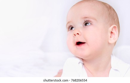 Happy Smiling Child With Wide Open Brown Eyes On White Background. Close Up Portrait. Happy Childhood Concept