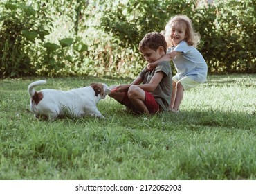 Happy Smiling Children Playing Tug-of-war Game With Their Stubborn Pet Dog