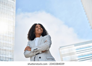 Happy smiling confident young African American professional business woman leader wearing suit standing in big city on street arms crossed thinking of success, dreaming, feeling proud outdoors. - Powered by Shutterstock