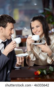 Happy Smiling Couple In Cafe With Cups In Hands