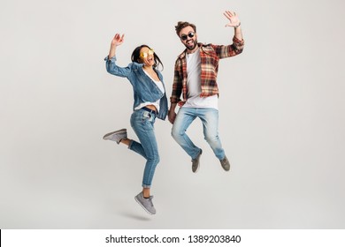 Happy Smiling Couple Isolated Active Jumping On White Studio Background, Stylish Mand And Woman In Casual Denim Hipster Outfit Wearing Shirt And Sunglasses Having Fun Together, Dating Friends