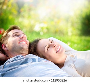 Happy Smiling Couple Relaxing on Green Grass.Park.Young Couple Lying on Grass Outdoor - Powered by Shutterstock