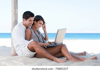 Happy smiling couple surfing the net and enjoy the summer at tropical beach - Powered by Shutterstock