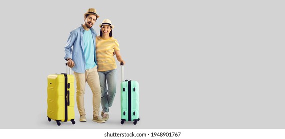 Happy Smiling Couple Tourist Traveler With Luggage Suitcase Travel Bag Standing Hugging Looking At Camera. Full Body Studio Portrait With Empty Copy Space Aside. Vacation Time, Advertisement