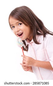 happy, smiling cute little girl eating marshmallow sweet candy