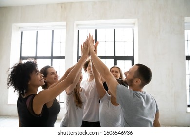 Happy Smiling Diverse People Sharing Success, Giving High Five After Training In Modern Fitness Center, Yoga Studio Staff Celebrating Good Teamwork Result, Engaged In Team Building Activity