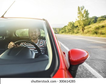 Happy Smiling Driver Man In New Red Car On The Road. Toned Photo.