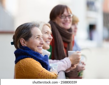 Happy smiling elderly women drinking coffee at patio - Powered by Shutterstock