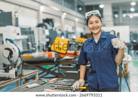 happy smiling engineer worker standing portrait thumbs up in modern metal workshop plant factory