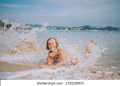 Happy Smiling Excited Elderly Senior Woman Tourist Playing In Water And Swimming In The Big Waves On The Ocean Sea Beach. Traveling Along Asia, Active Lifestyle Concept.