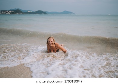 Happy Smiling Excited Elderly Senior Woman Tourist Playing In Water And Swimming In The Big Waves On The Ocean Sea Beach. Traveling Along Asia, Active Lifestyle Concept.