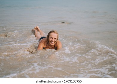 Happy Smiling Excited Elderly Senior Woman Tourist Playing In Water And Swimming In The Big Waves On The Ocean Sea Beach. Traveling Along Asia, Active Lifestyle Concept.