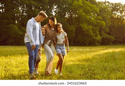 Happy smiling family of four with two kids boy and girl walking in summer park enjoying beautiful nature. Young joyful parents and their children hugging outdoors enjoying time together. - Powered by Shutterstock