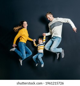 Happy Smiling Family Jump On Black Background..