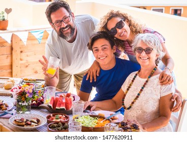 Happy and smiling family, multigeneration. Couple with son and grandma enjoying brunch or meal together. Sunlight on the terrace field - Powered by Shutterstock