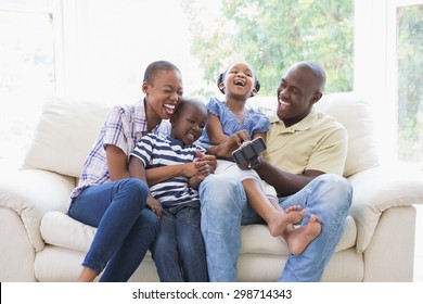 Happy smiling family on the couch in the living room. Social distancing and self isolation in quarantine lockdown for Coronavirus Covid19
 - Powered by Shutterstock