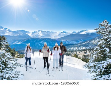 Happy Smiling Family Skiing On Winter Vacation. Sun Shining On Snow Capped Mountains. Rocky Mountain National Park. Close To Estes Park, Colorado, USA