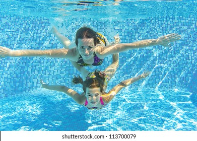 Happy Smiling Family Underwater In Swimming Pool. Mother And Child Swim And Having Fun. Kids Sport On Family Summer Vacation. Active Healthy Holiday