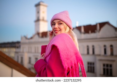 Happy smiling fashionable woman wearing trendy total pink outfit with knitted beanie hat, woolen fringed scarf, coat, posing outdoor. Copy, empty space for text - Shutterstock ID 2237132295