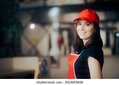 Happy Smiling Fast-Food Worker Standing In A Restaurant. Waitress Working Greeting Customers With Friendly Smile
