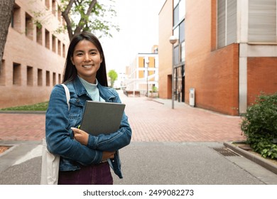 Happy smiling female asian teen college student on campus holding books looking at camera. Copy space. Education concept. - Powered by Shutterstock