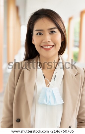 Happy smiling ffice worker going to work with removed face mask but still having mask as precaution