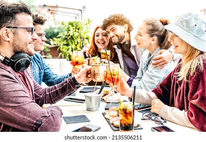 Happy smiling friends drinking spritz and moscow mule at cocktail bar restaurant - Friendship concept with young multiracial people having fun together toasting drinks on happy hour at outside pub - Powered by Shutterstock