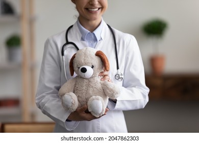 Happy Smiling General Pediatrician Cropped Shot Portrait. Young Female Indian Children Doctor With Stethoscope Holding Teddy Bear Plush Toy, Smiling At Camera. Infant Healthcare Concept. Close Up