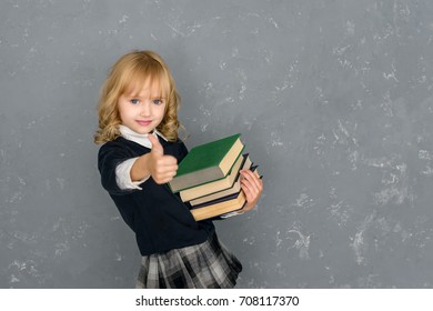 Happy smiling girl with a big thumbs up goes to school for the first time. children are our future. Back to school!  Concept of education and reading. The development  of the imagination. - Powered by Shutterstock