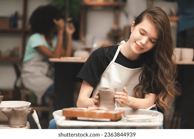 happy smiling girl having fun to learning and work with craft art of clay hand-made workshop in ceramic studio, little ceramist enjoy in creative handcraft hobby with pottery artisan school class - Powered by Shutterstock