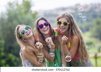 happy smiling group of teen girls blowing bubbles