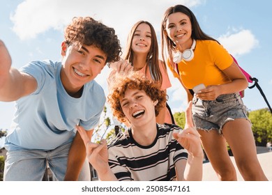 Happy smiling group of teenagers high school pupils friends classmates college students boys and girls with bags hanging out in park nature street outside take selfie shot picture photo having fun - Powered by Shutterstock