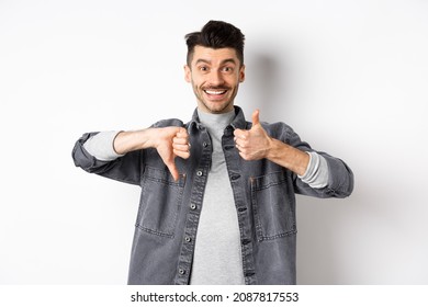 Happy Smiling Guy Showing Average Gesture, Thumbs Down Up, Cant Decide, Judging Something Medium, Standing On White Background