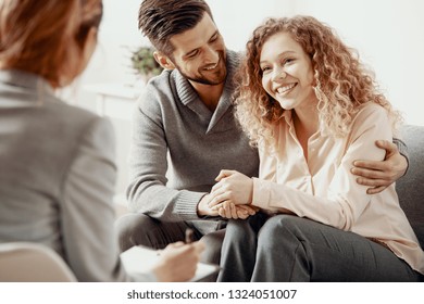 happy smiling husband and wife during therapy session with a psychologist